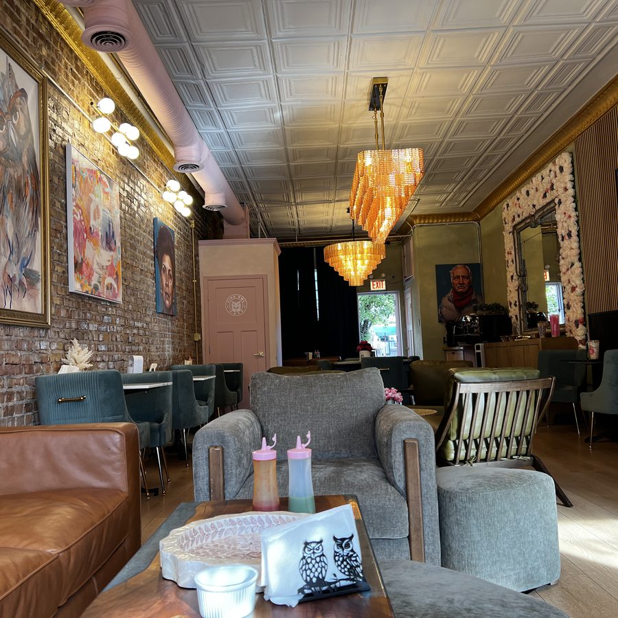 The new room: amber chandeliers under the pressed-tin ceiling, paintings along the exposed brick